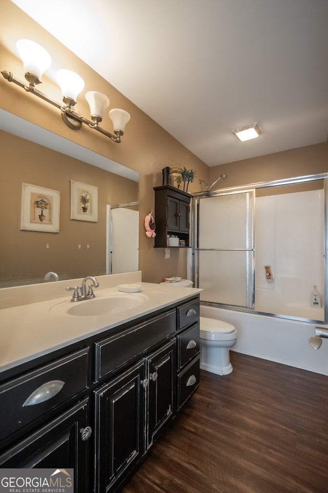 full bathroom featuring combined bath / shower with glass door, vanity, toilet, and hardwood / wood-style flooring