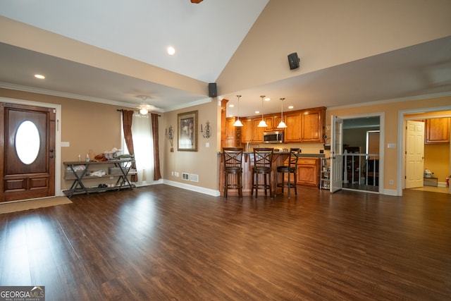 unfurnished living room featuring high vaulted ceiling, dark hardwood / wood-style floors, and crown molding