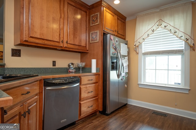 kitchen featuring appliances with stainless steel finishes, dark hardwood / wood-style floors, and ornamental molding