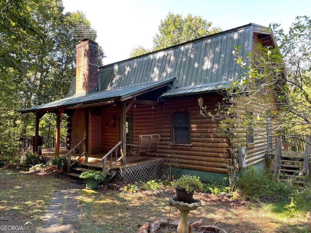 log home featuring covered porch