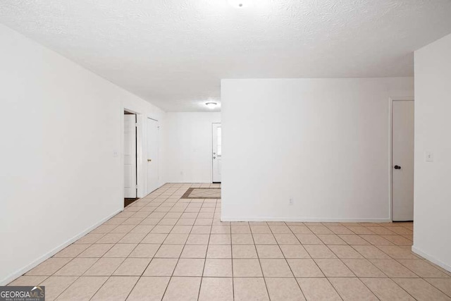 tiled spare room with a textured ceiling