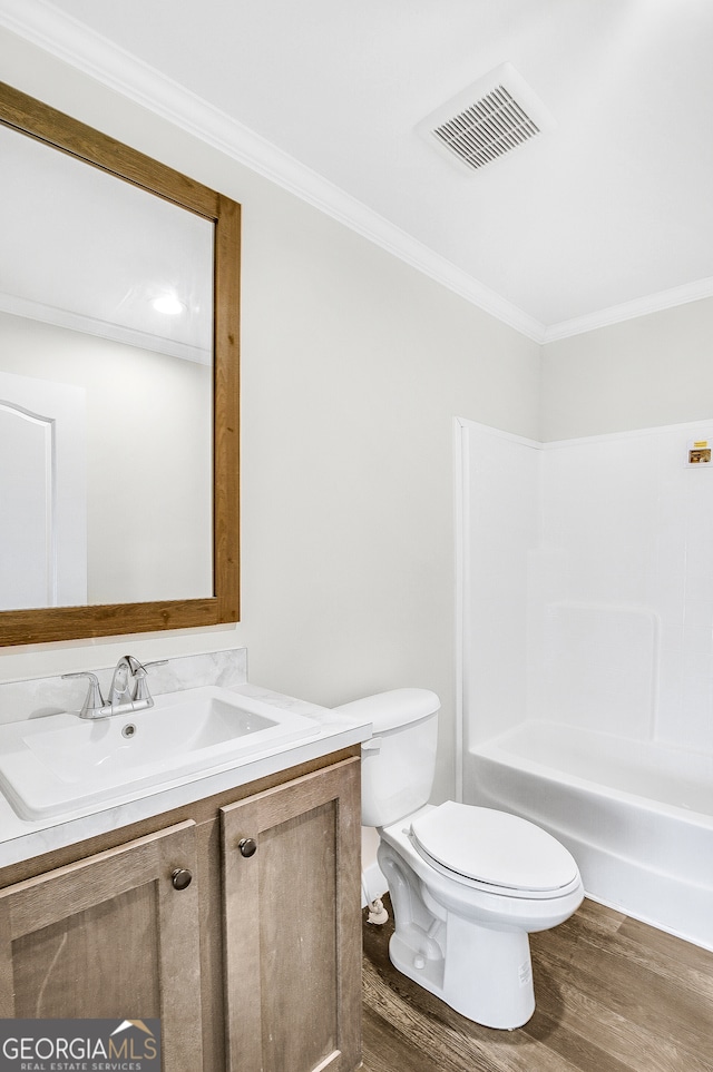 full bathroom featuring vanity, bathing tub / shower combination, crown molding, hardwood / wood-style flooring, and toilet