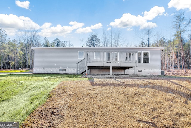 manufactured / mobile home featuring a front yard and a deck