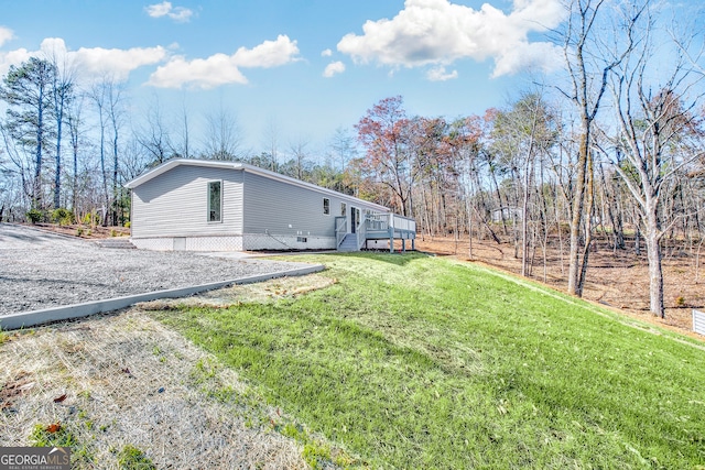 view of side of home featuring a deck and a lawn