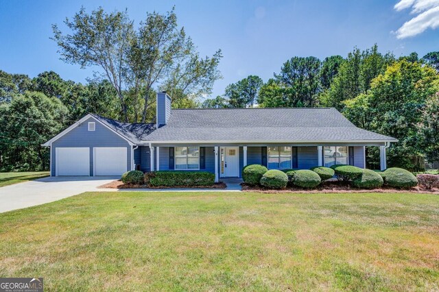 ranch-style home featuring a front lawn, a garage, and covered porch