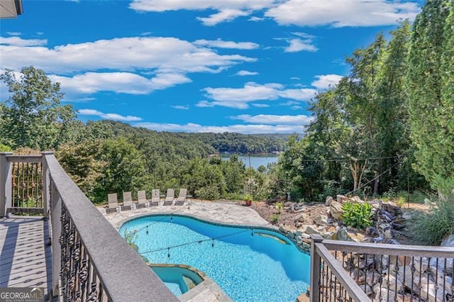 view of swimming pool with a hot tub and a water view