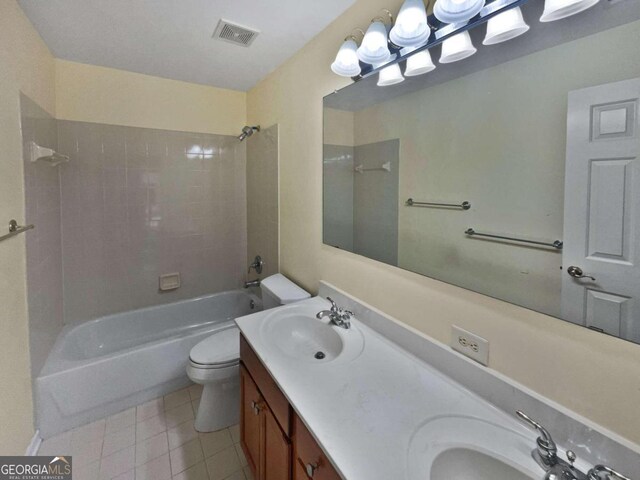 full bathroom with tile patterned floors, vanity, tiled shower / bath combo, and toilet