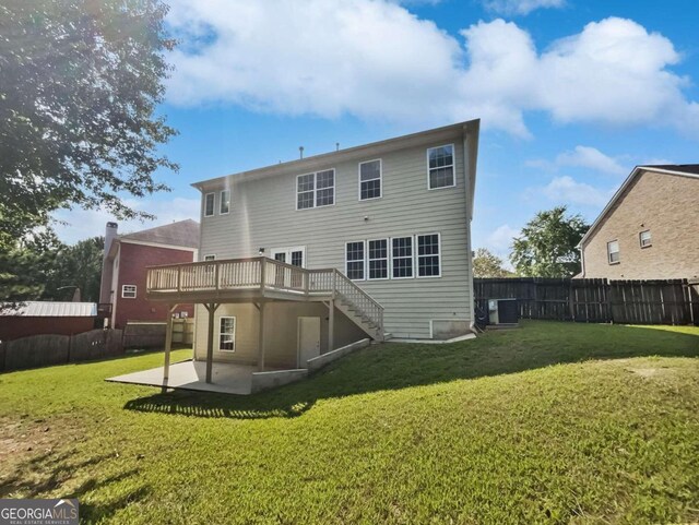 back of property with a deck, a patio area, and a yard