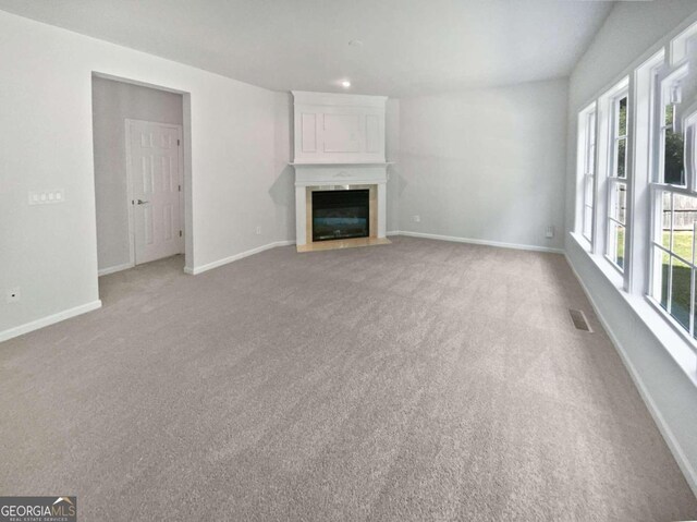 unfurnished living room featuring light colored carpet