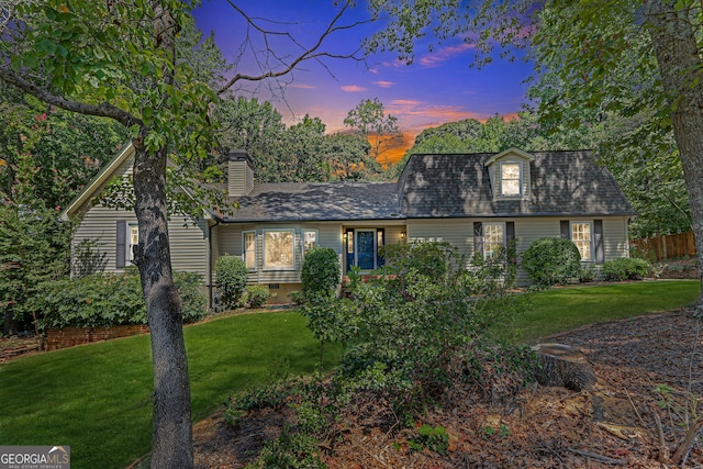 cape cod-style house featuring a lawn