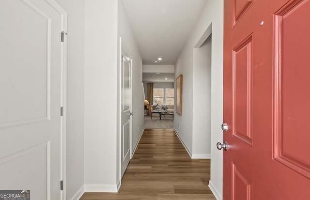 hall featuring baseboards and wood finished floors