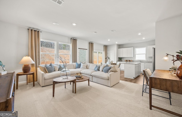 living area featuring recessed lighting and visible vents