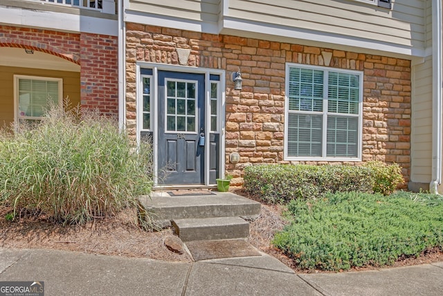 property entrance featuring stone siding