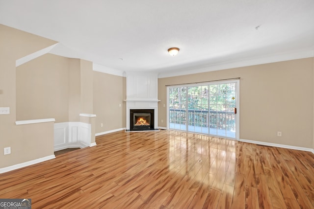 unfurnished living room featuring ornamental molding and light hardwood / wood-style floors