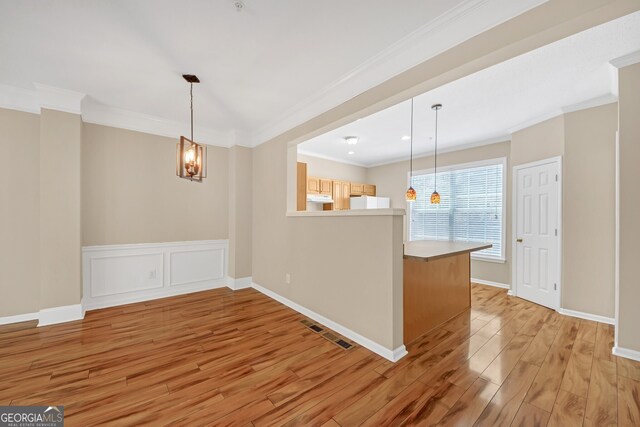 kitchen with light wood-type flooring, kitchen peninsula, stainless steel dishwasher, and sink