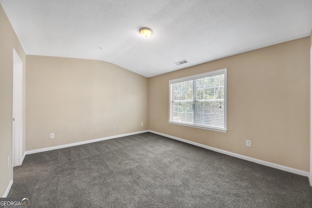 carpeted spare room featuring lofted ceiling and a textured ceiling