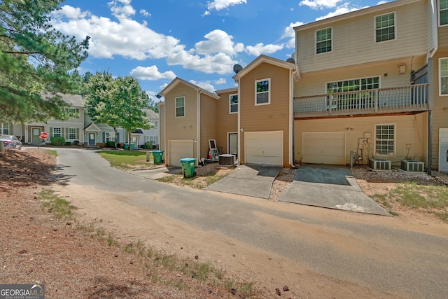 front of property with a balcony, a garage, and cooling unit