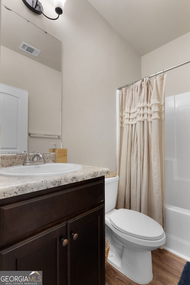 full bathroom with vanity, shower / tub combo with curtain, toilet, and wood-type flooring