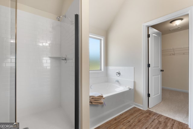 bathroom featuring vaulted ceiling, wood-type flooring, and shower with separate bathtub