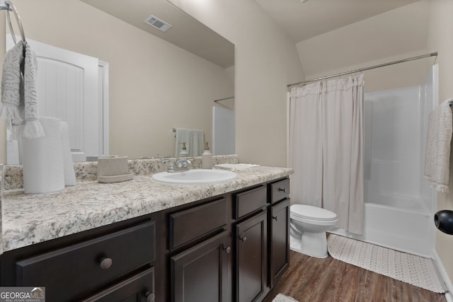 full bathroom featuring vanity, lofted ceiling, hardwood / wood-style flooring, toilet, and shower / tub combo with curtain