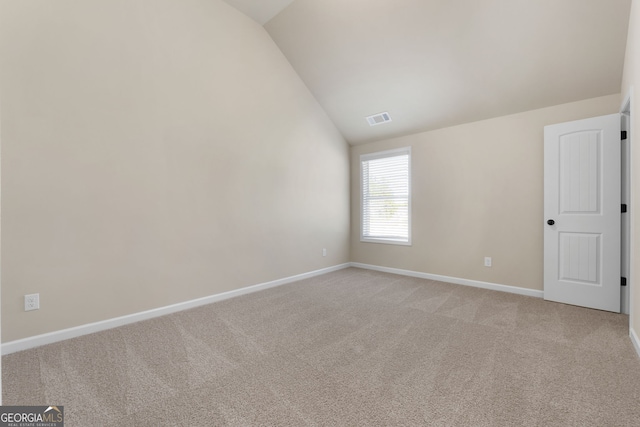 unfurnished room with vaulted ceiling and carpet