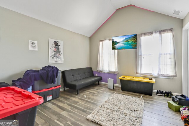 living room featuring hardwood / wood-style flooring and vaulted ceiling