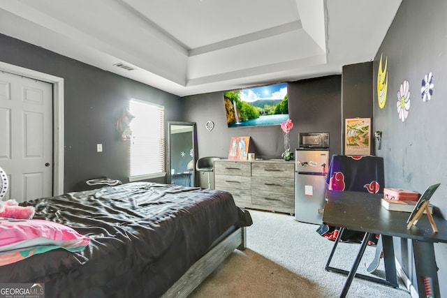 bedroom featuring a tray ceiling and carpet