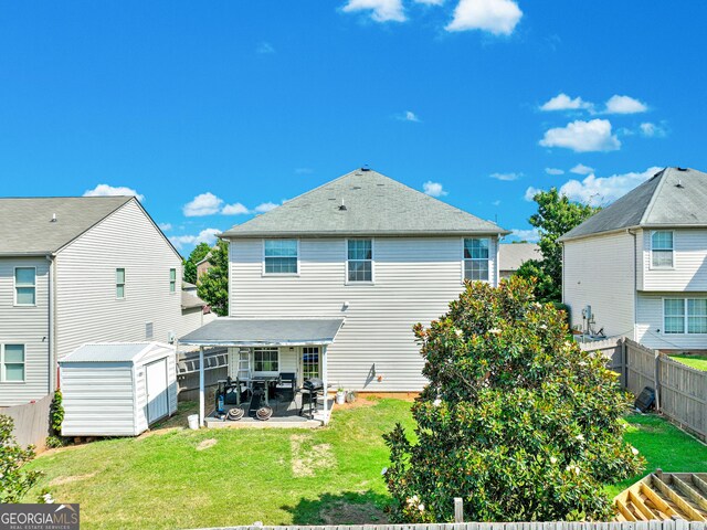 back of property with a patio area, a yard, and a shed