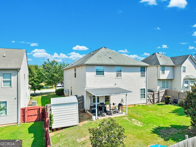 rear view of property featuring a patio area and a lawn