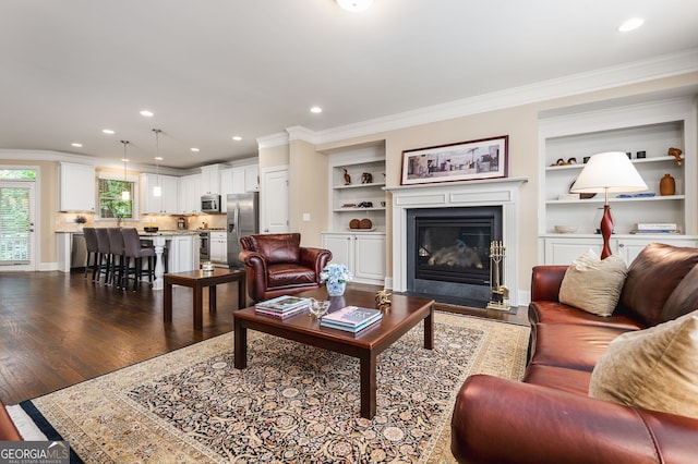 living room featuring ornamental molding, dark hardwood / wood-style floors, and built in shelves