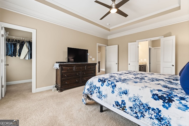 bedroom featuring a raised ceiling, ceiling fan, a closet, and light colored carpet