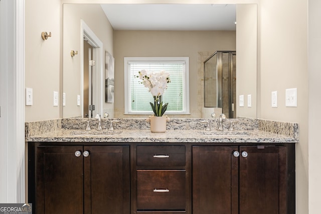 bathroom with vanity and a shower with door