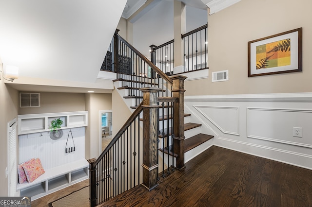 staircase with ornamental molding and hardwood / wood-style flooring