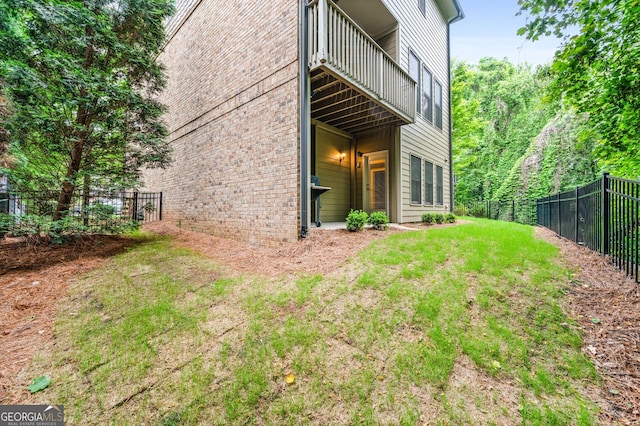 back of property featuring a balcony and a yard