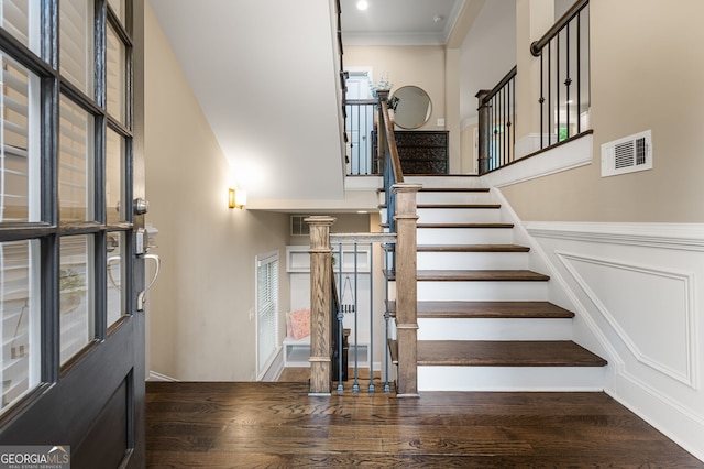 staircase featuring crown molding and hardwood / wood-style floors