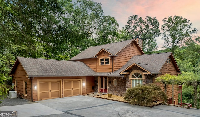 view of front of property featuring a garage and central air condition unit