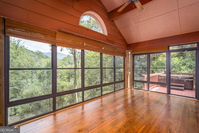 unfurnished sunroom featuring ceiling fan, lofted ceiling, and a wealth of natural light