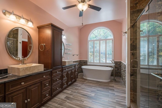 bathroom with vanity, hardwood / wood-style flooring, ceiling fan, tile walls, and independent shower and bath