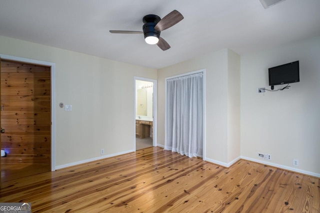 unfurnished bedroom featuring light wood-type flooring, a closet, ceiling fan, and connected bathroom