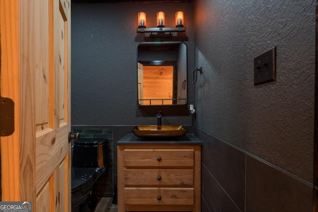 bathroom featuring vanity and tile walls