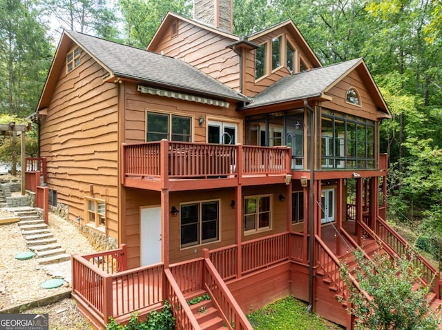 exterior space featuring a wooden deck and a sunroom