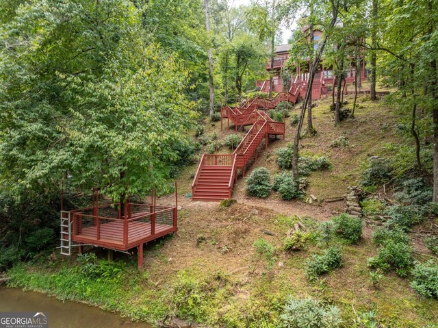 view of yard with a deck with water view