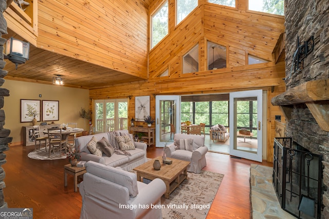 living room featuring a fireplace, a healthy amount of sunlight, and a high ceiling