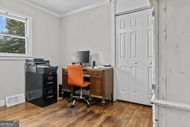 office with ornamental molding, visible vents, and light wood-style flooring