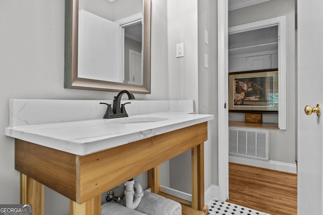 bathroom with vanity, wood finished floors, visible vents, and baseboards