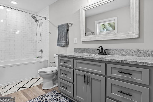 full bathroom featuring toilet, shower / tub combination, wood finished floors, and vanity