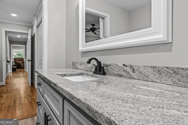 bathroom with recessed lighting, wood finished floors, a ceiling fan, vanity, and ornamental molding