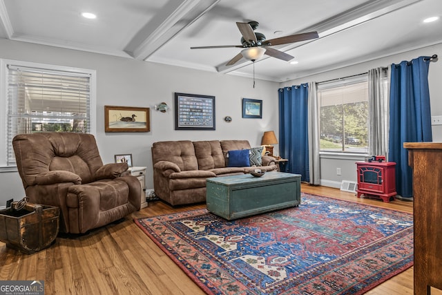 living area featuring baseboards, ceiling fan, ornamental molding, wood finished floors, and beam ceiling