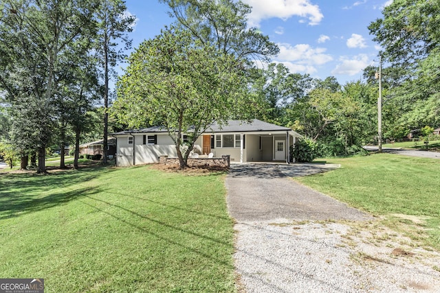 ranch-style home with a carport, aphalt driveway, and a front yard