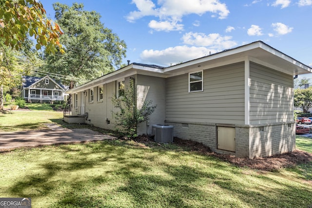 view of home's exterior featuring crawl space, central AC, and a lawn